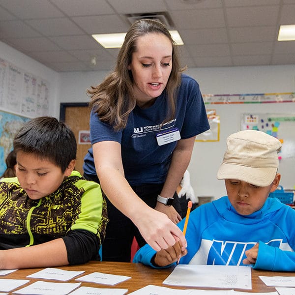 Hannah Gish helps a young student with an assignment.
