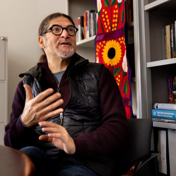 Professor Luis Fernandez, in his office, talks with a colleague.