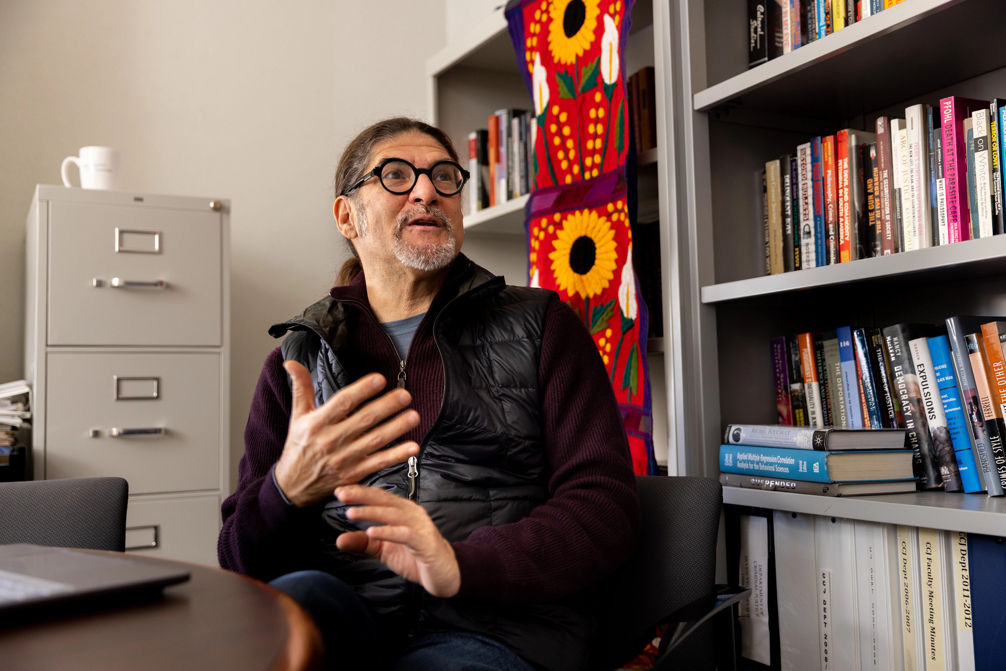 Professor Luis Fernandez, in his office, talks with a colleague.