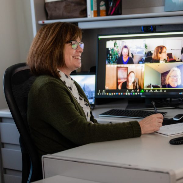 Department of Psychological Sciences Associate Professor Ronda Jenson sitting at her desk visiting with colleagues during a zoom call.