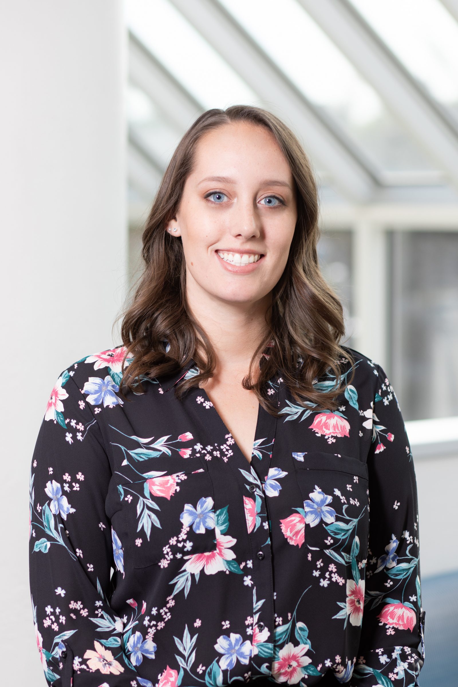 Portrait of Hannah Gish wearing a floral-patterned, button-down shirt.