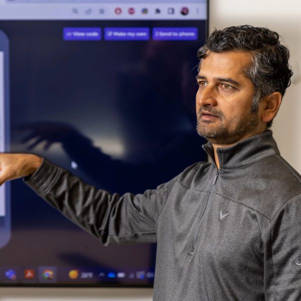 School of Informatics, Computing, and Cyber Systems Associate Professor Ashish Amresh talks in front of a slide showing Hopi art and the words, "Hopi Naatoyta.