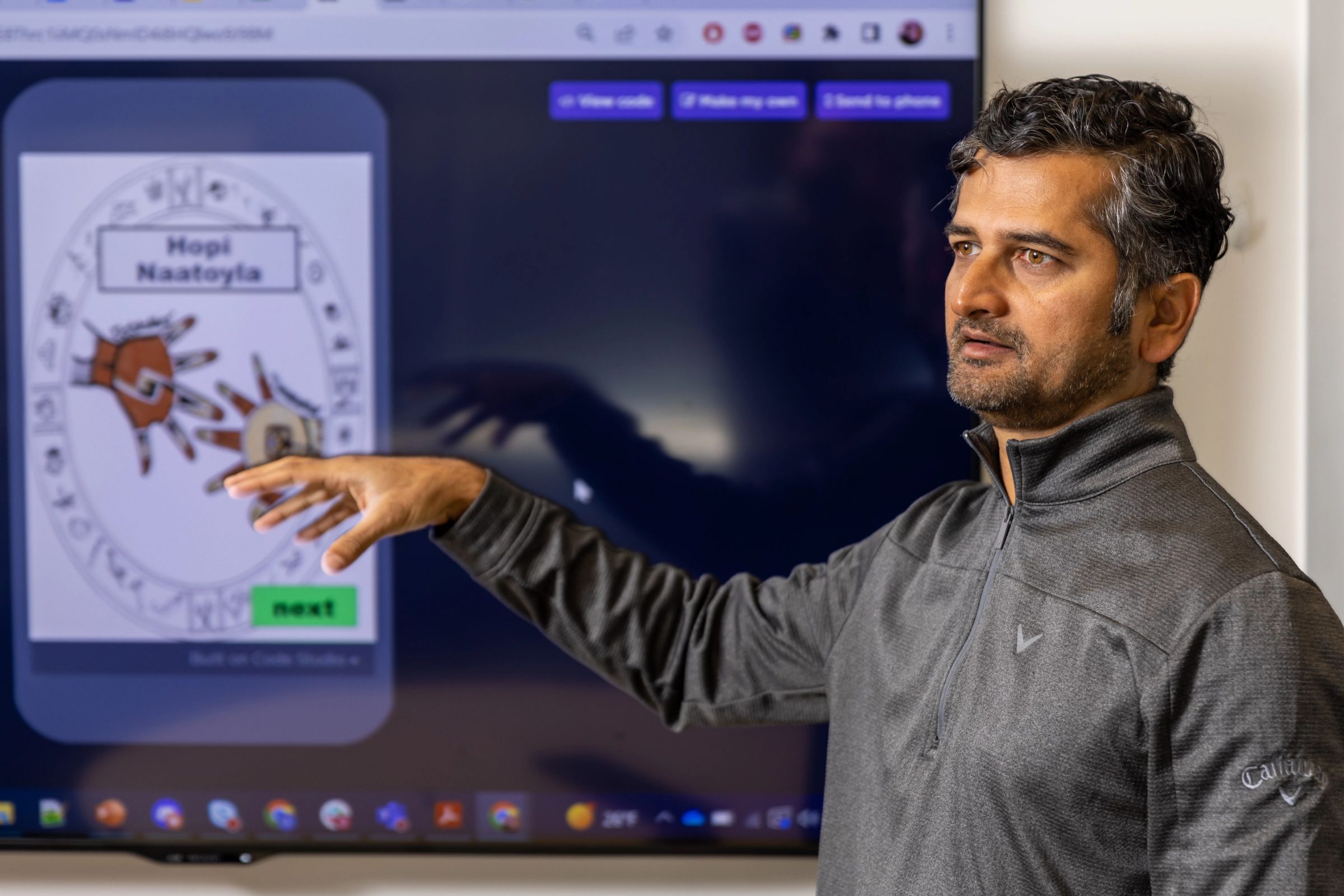 School of Informatics, Computing, and Cyber Systems Associate Professor Ashish Amresh talks in front of a slide showing Hopi art and the words, "Hopi Naatoyta.