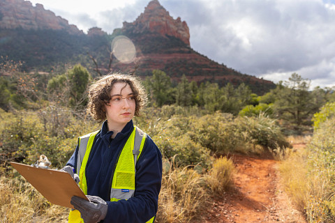 Student Helena Moomjian stands on a Sedona trail with a clipboard.