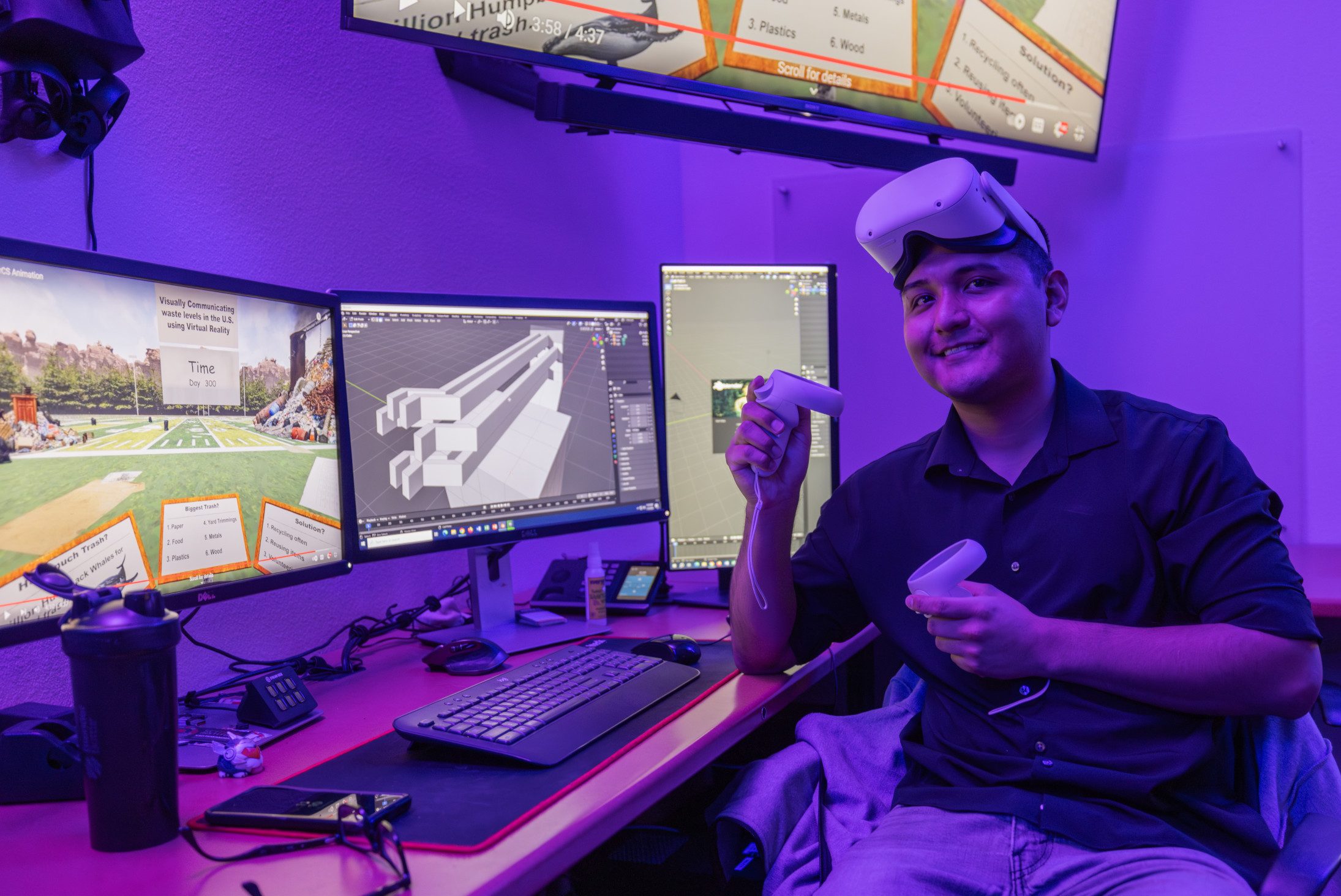 N A U senior Visual Communication student, Dadric Riggs, smiles while showcasing the virtual reality equipment used for their research on waste issues in the United States.