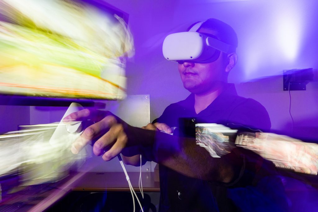 N A U senior Visual Communication student, Dadric Riggs, demonstrates how they used virtual reality for their research on waste issues in the United States.