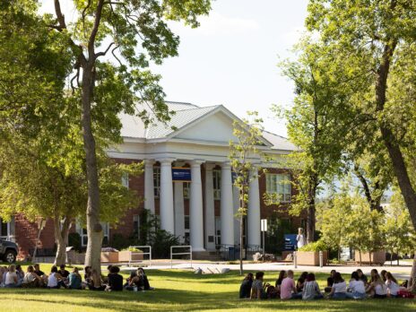 students sitting in groups at the park