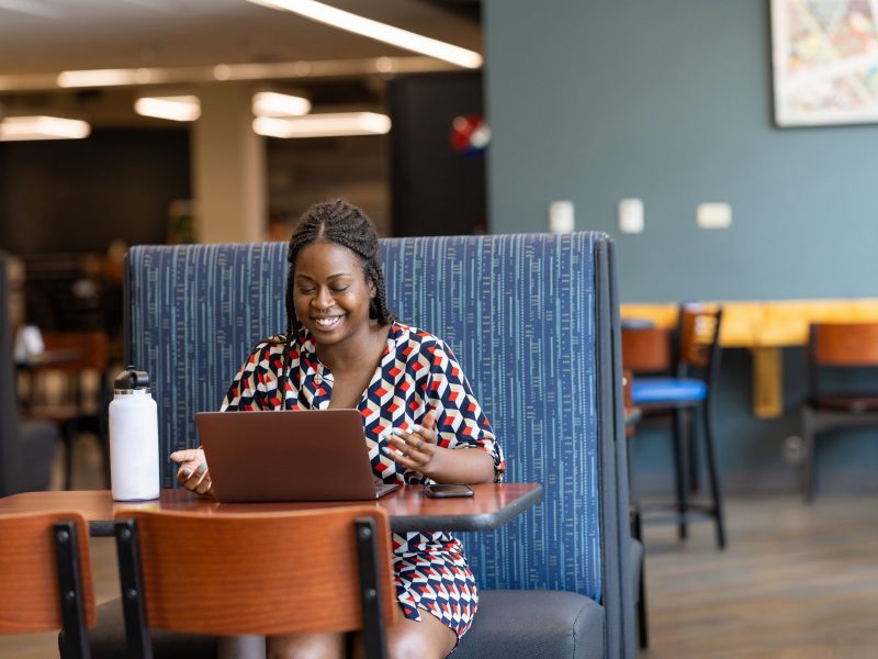 An N A U Online graduate student attending class online from a coffee shop.