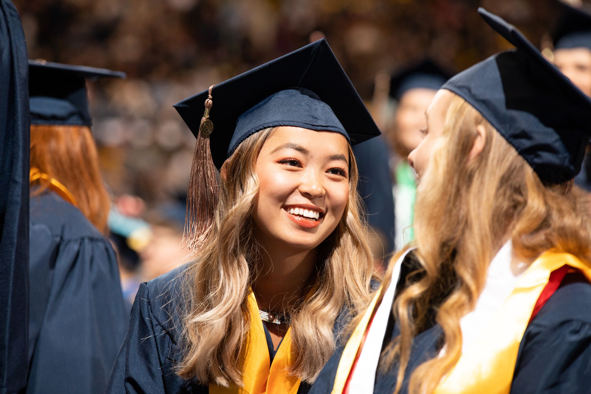 Students talking at their graduation ceremony.
