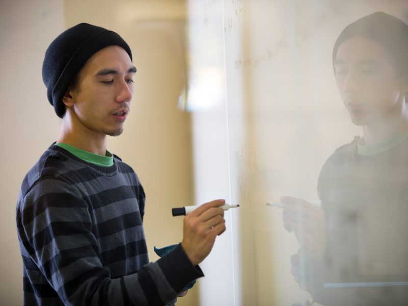 A student writing on a whiteboard.