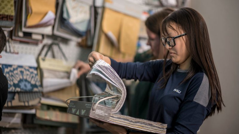 Student looking through different fabrics for their design class.