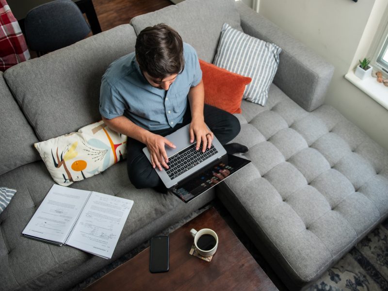 An N A U student working online on their couch.
