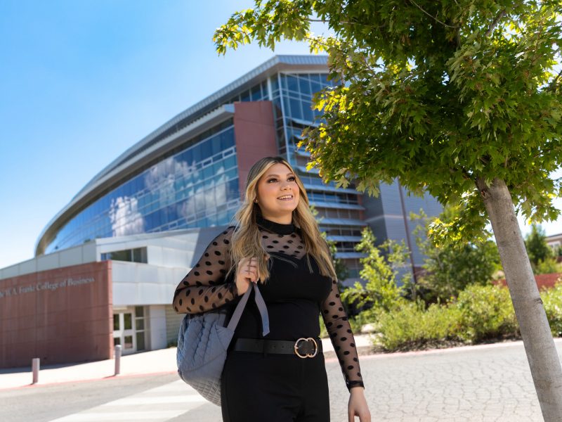 Business student in business attire standing outside the W A Franke College of Business.
