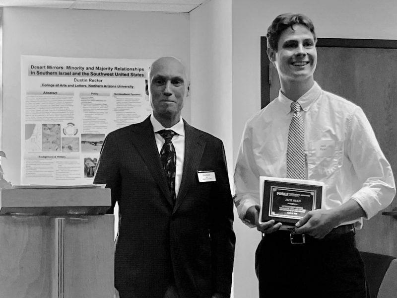 Jack Ryan, Philosophy's Outstanding Senior, accepts their award from Dean Boyer the morning of commencement in the Riles Building.