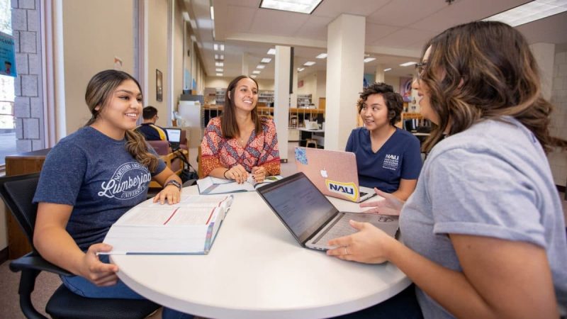 Cuatro estudiantes de NAU estudiando juntos alrededor de una mesa.