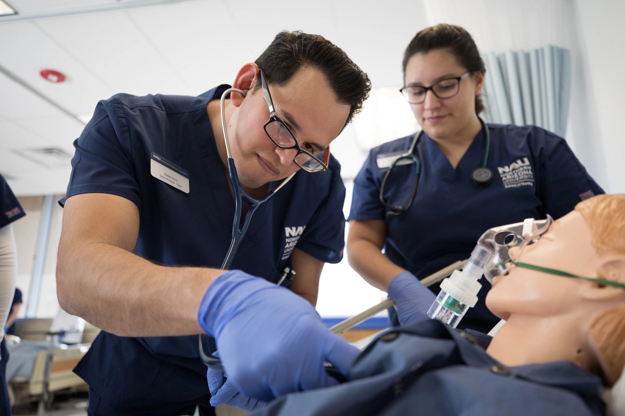 Estudiantes de enfermería en NAU practicando técnicas de medicina en un maniquí.