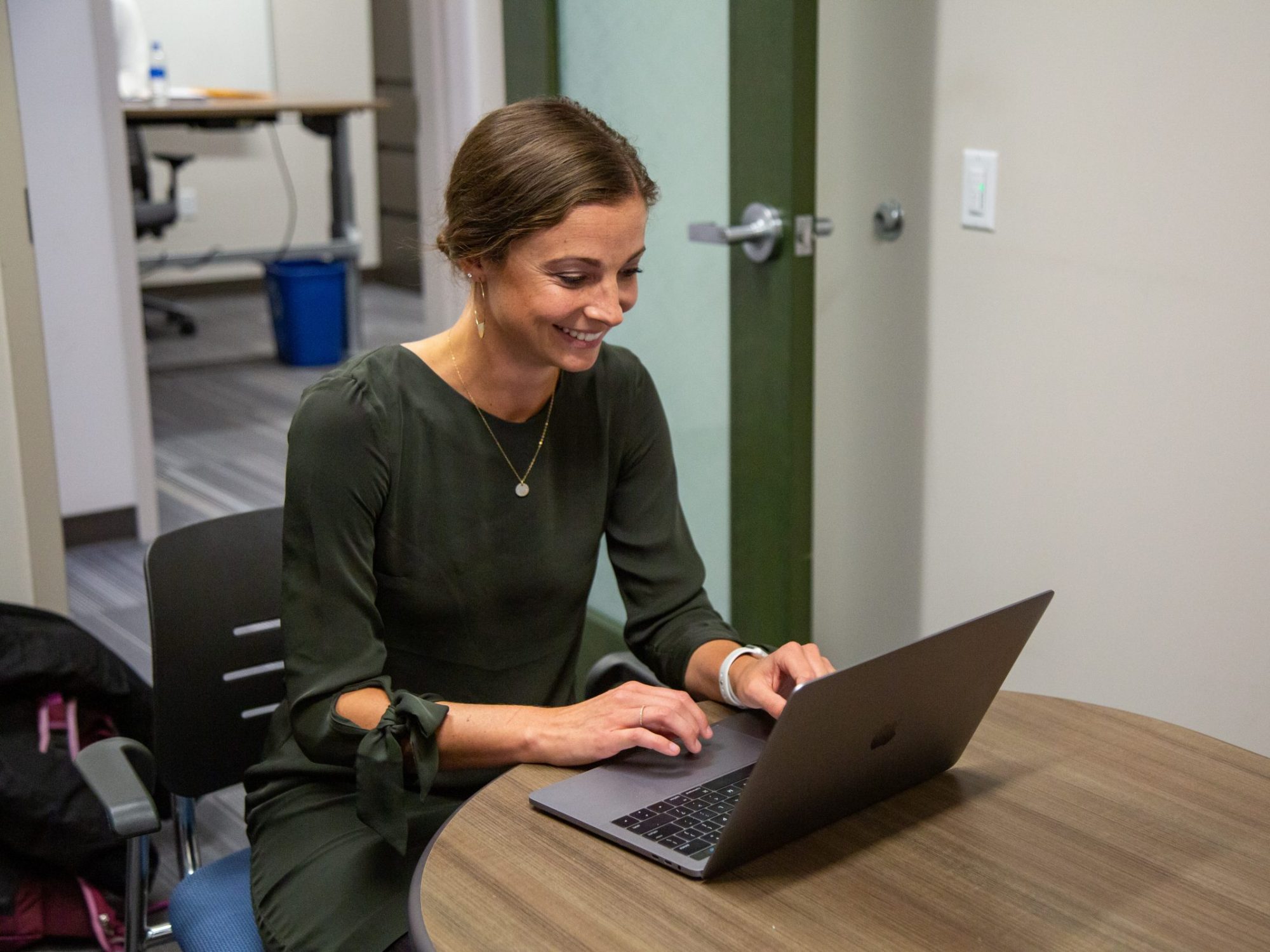 El candidato a doctorado de NAU Taylor Lane se sienta en una mesa con una computadora port&aacute;til.