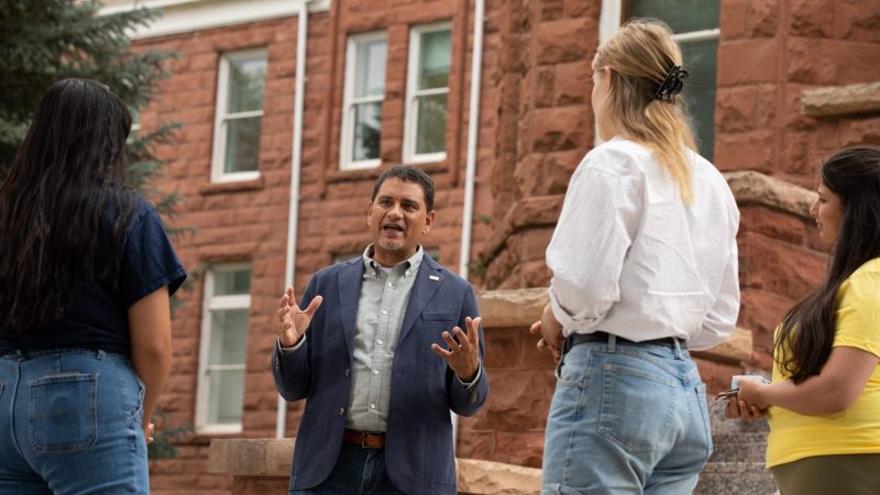 Presidente José Luis Cruz Rivera de NAU habla con estudiantes enfrente del edificio Old Main.