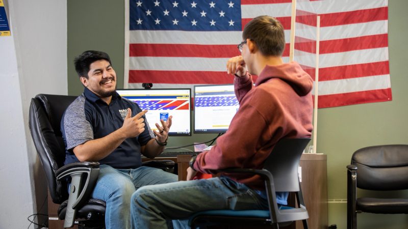 Dos estudiantes de NAU se sientan juntos y hablan en el Centro de Éxito para Veteranos.