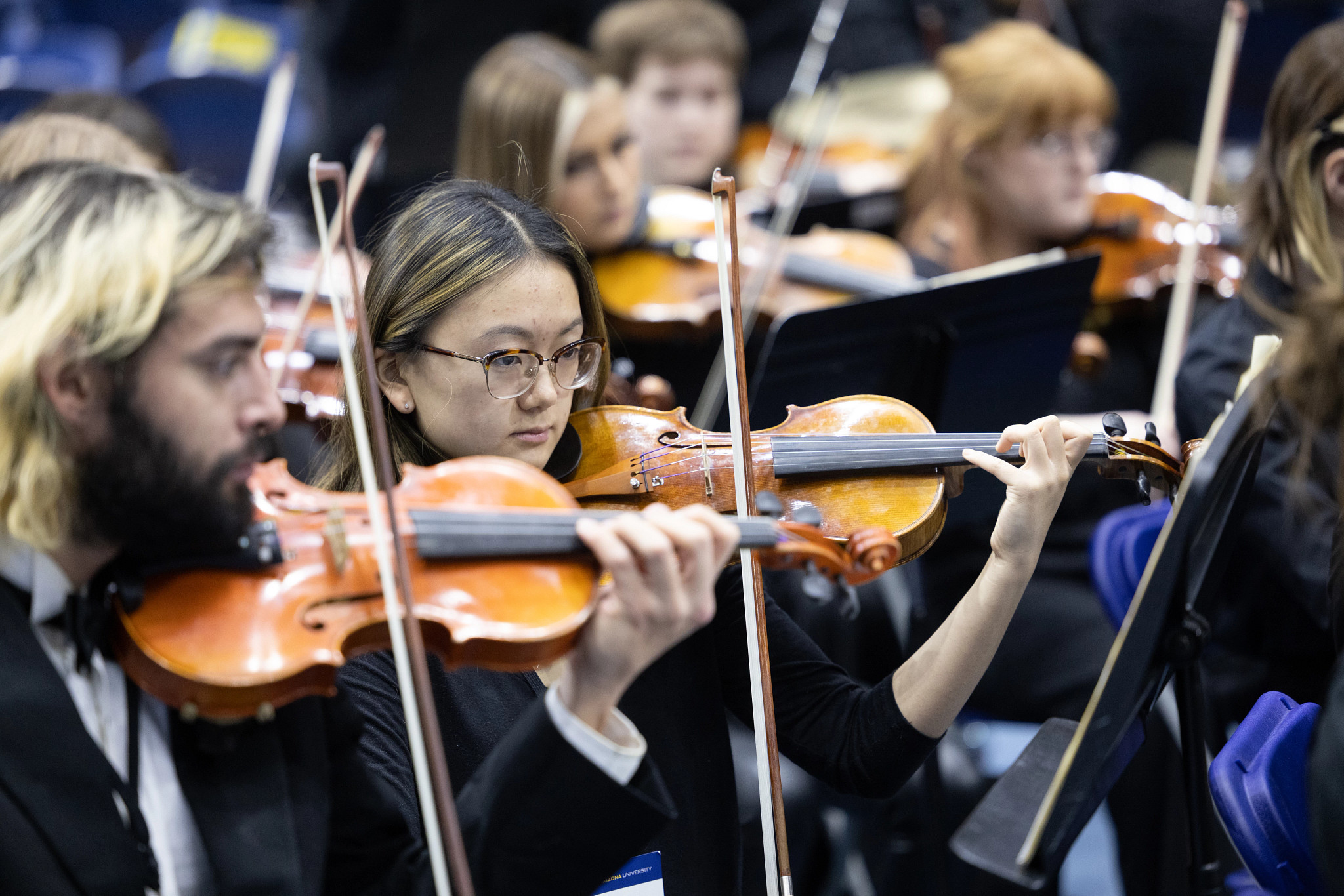 Violin section of the NAU orchestra performing.