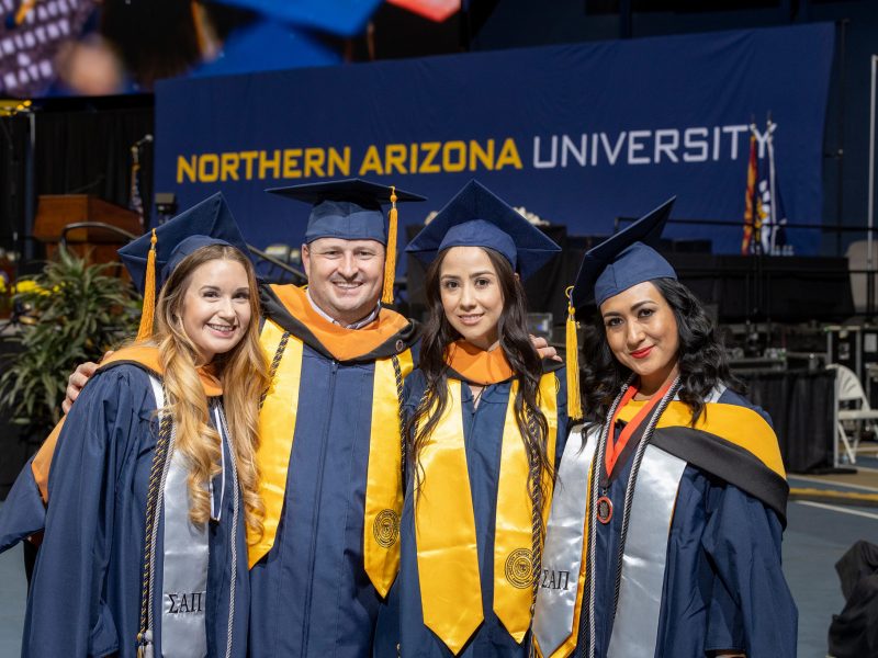Four new graduates smiling.