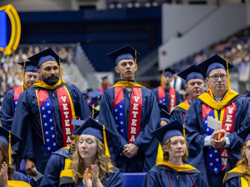 NAU military veteran students stand to be recognized during commencement