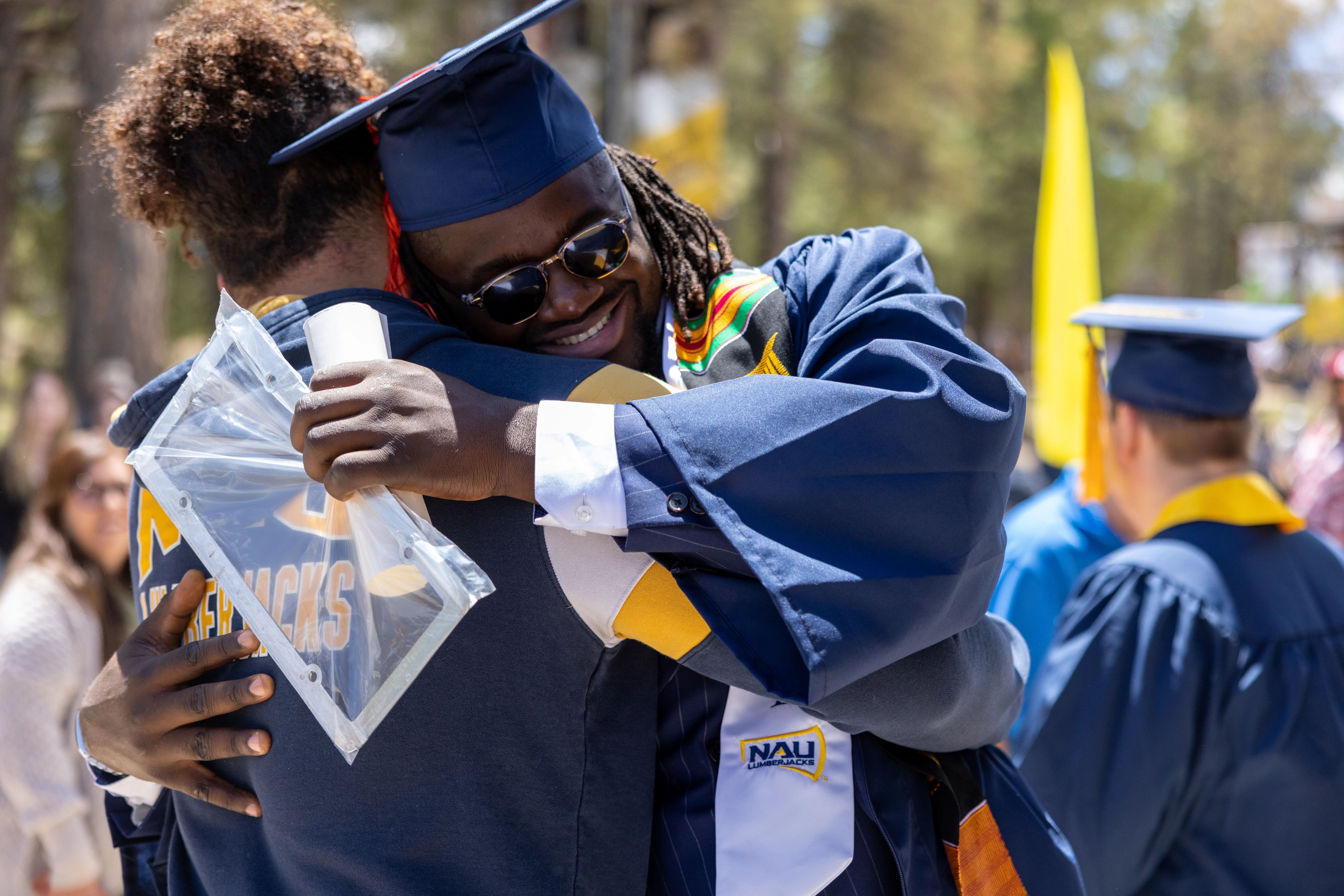 NAU grad hugging a family member outside the Skydome after the ceremony