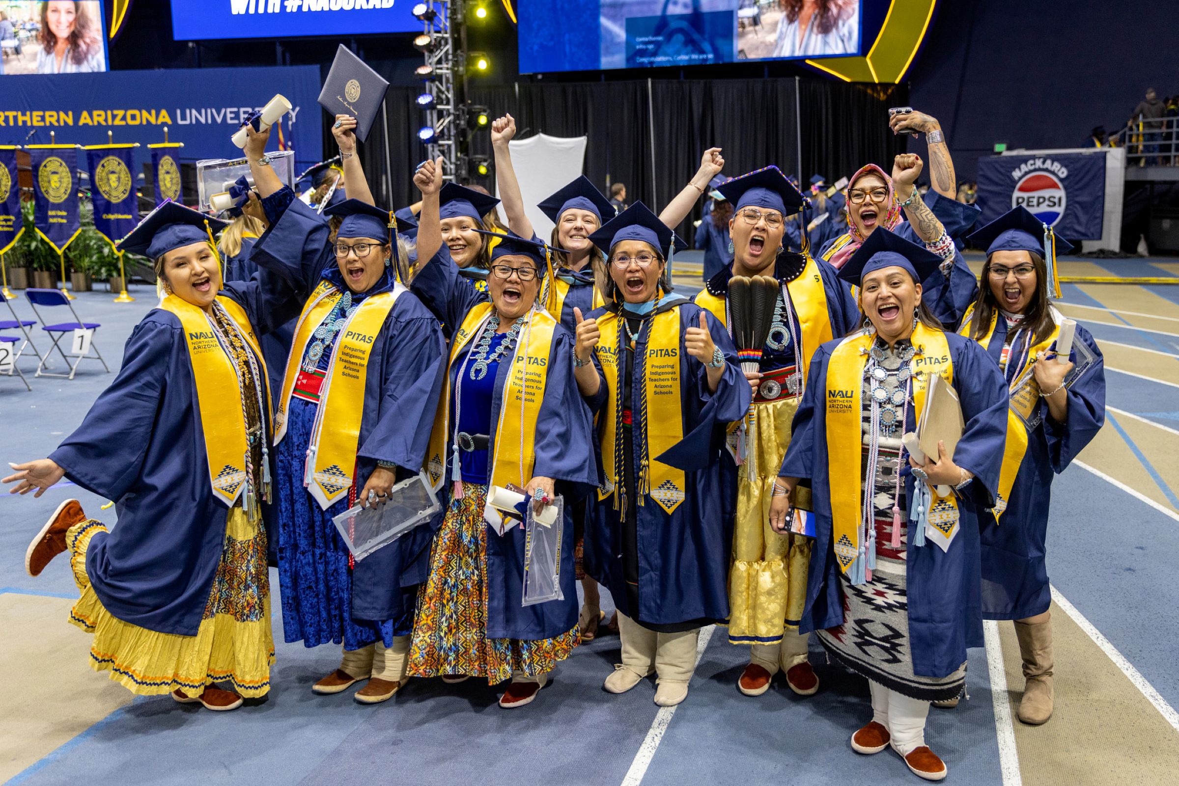 A diverse group of students celebrate at N A U commencement.