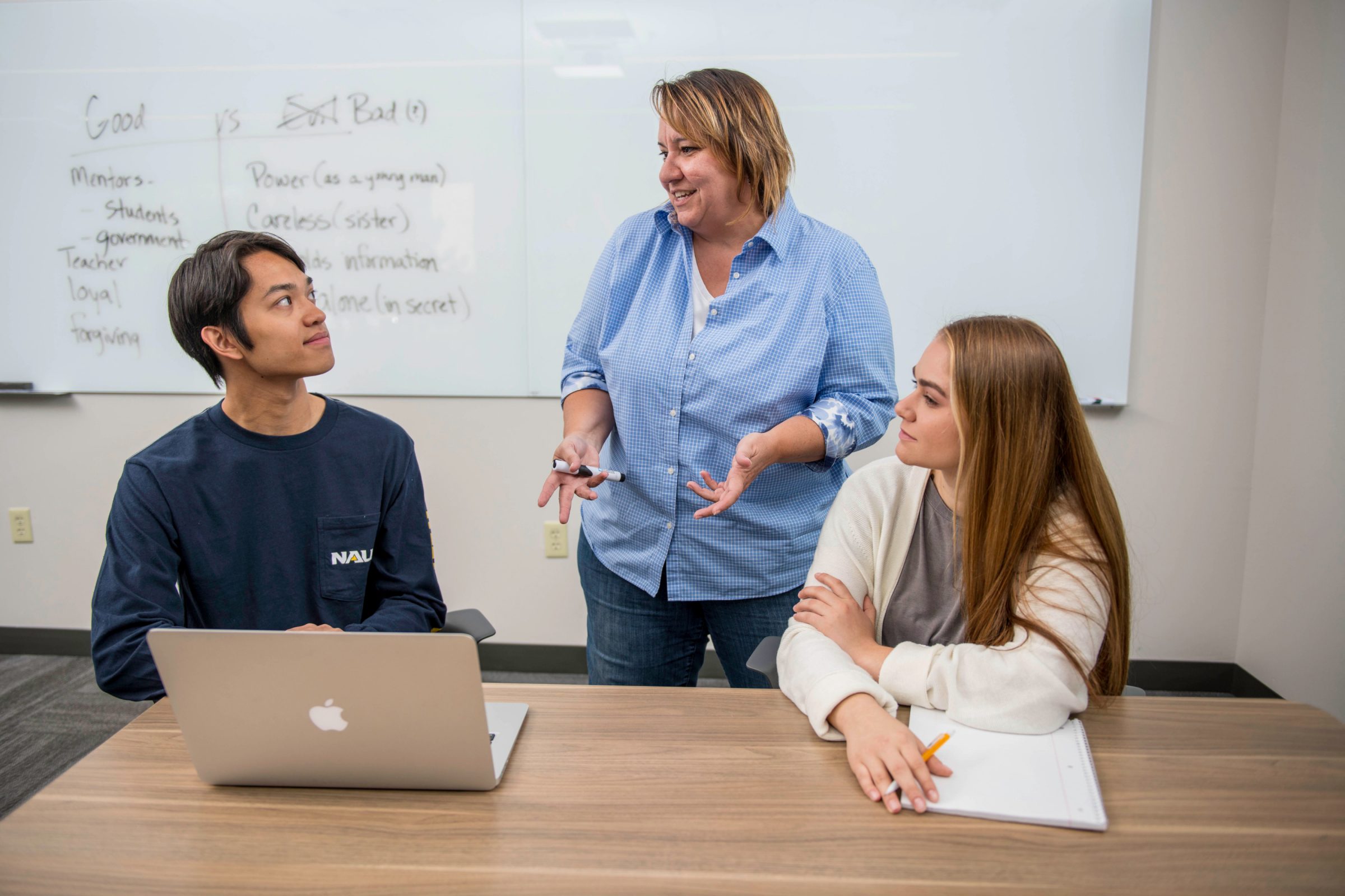 Two students having a conversation with an instructor.