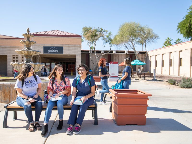Three nursing students sit at a picnic table at N A U's Yuma campus.
