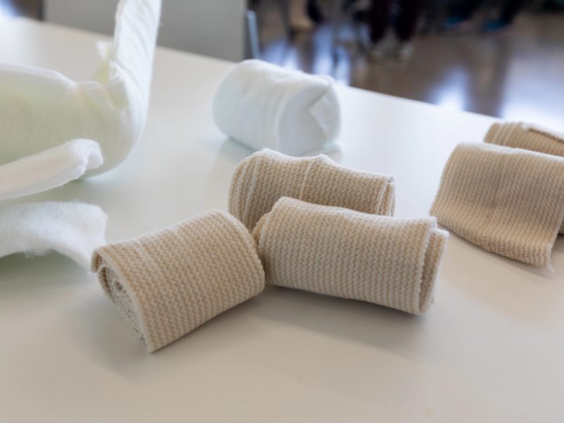Rolls of bandages and gauze sitting on a table.