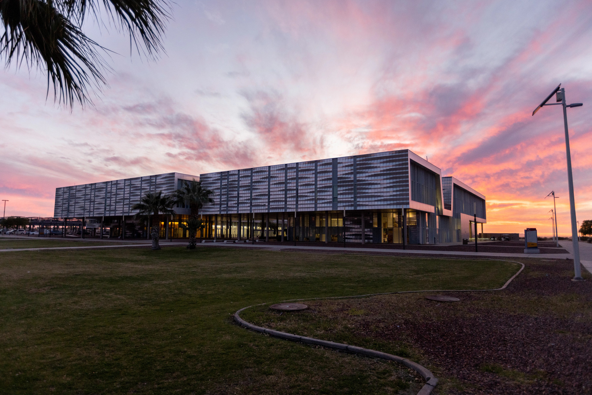 Campus building with a sunset in the background.