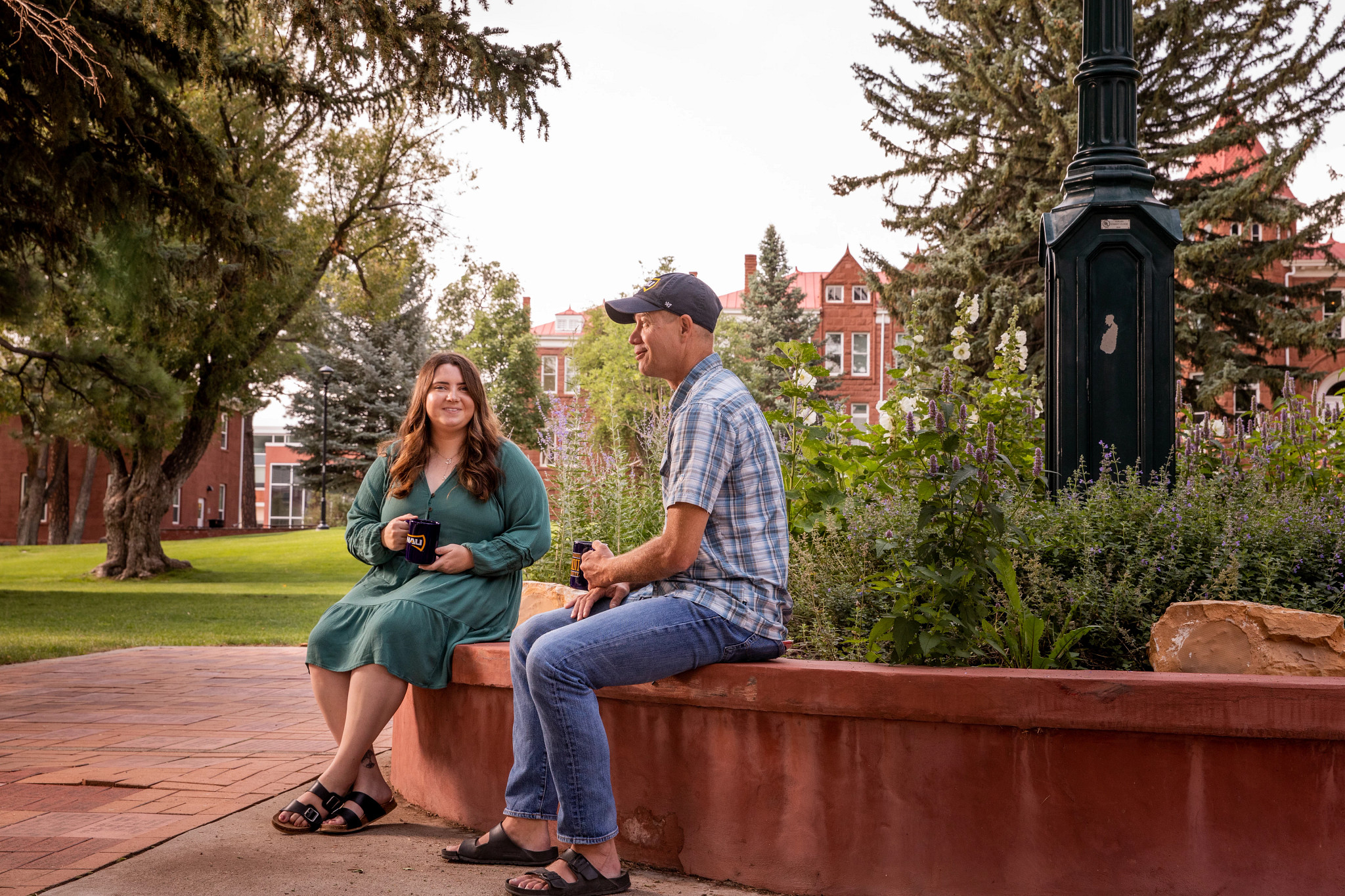 Two students relaxing on the grounds of N A U's mountain campus.
