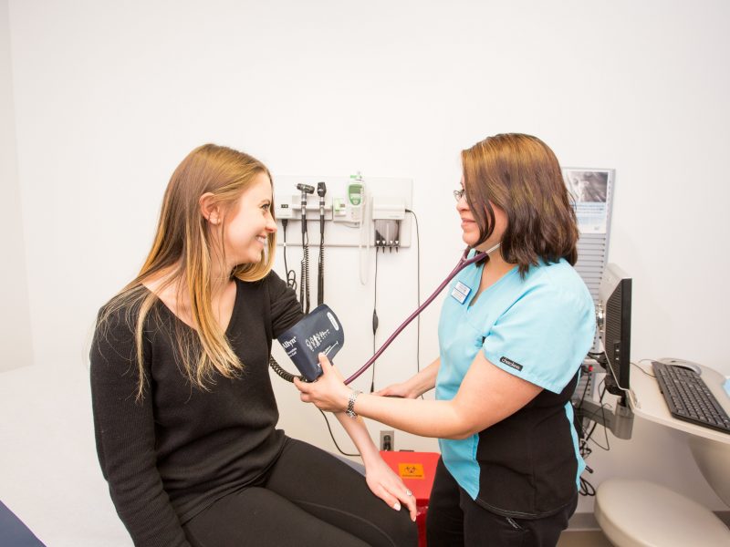 Student takes a patients blood pressure at N A U's campus health services.