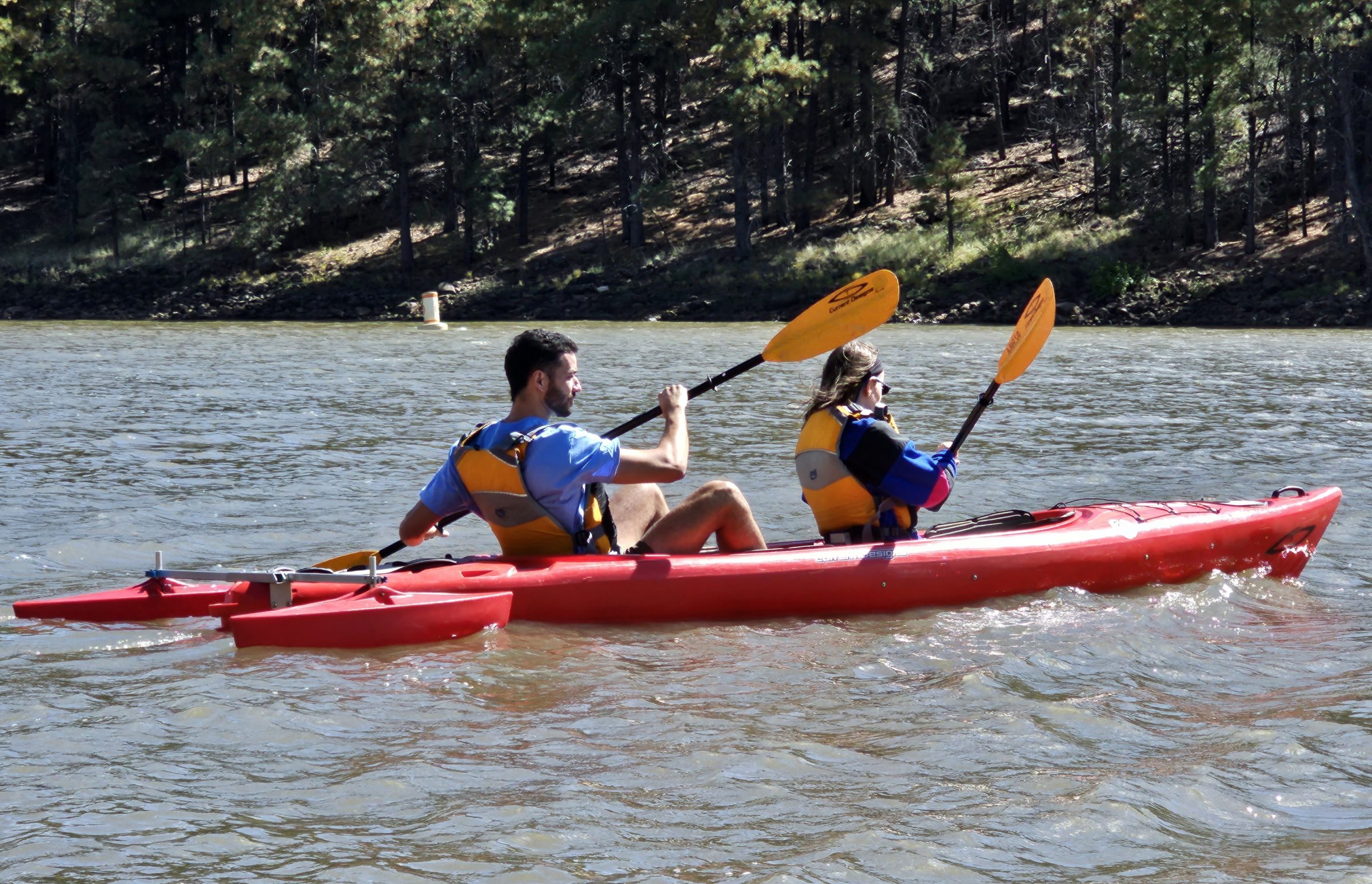 A man and woman kayaking on a lake.