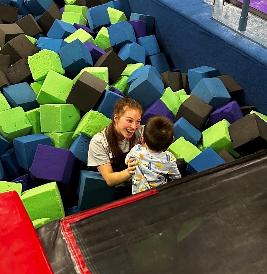 A person catching a child in a foam pit.