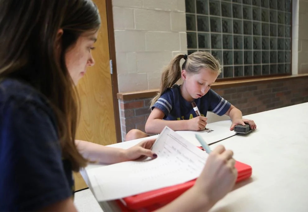 Evie Lewis, 10, right, works on a sight words activity during a literacy therapy session with speech-language pathology graduate student Sydney Konatske during the Reading Between the Pines summer camp July 1 at Northern Arizona University.