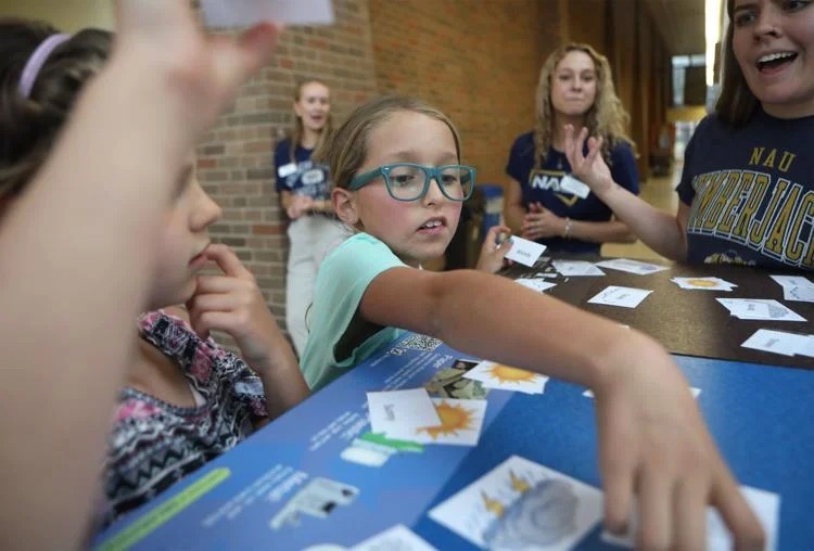 Ella Lewis, 10, looks to match words with pictures during a weather relay race activity at the Reading Between the Pines summer camp on Tuesday, July 1, at Northern Arizona University.
