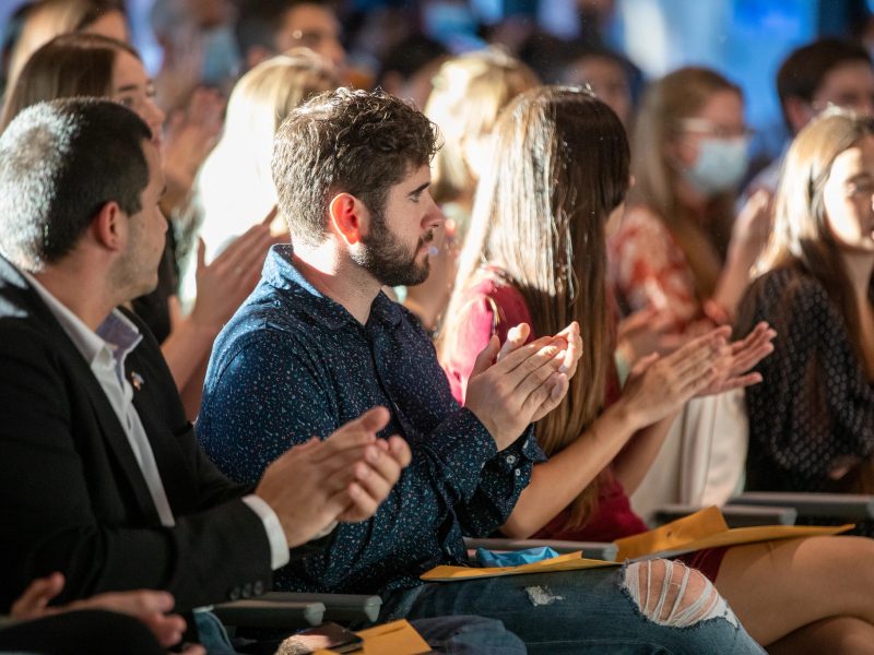 Students clapping at a ceremony.