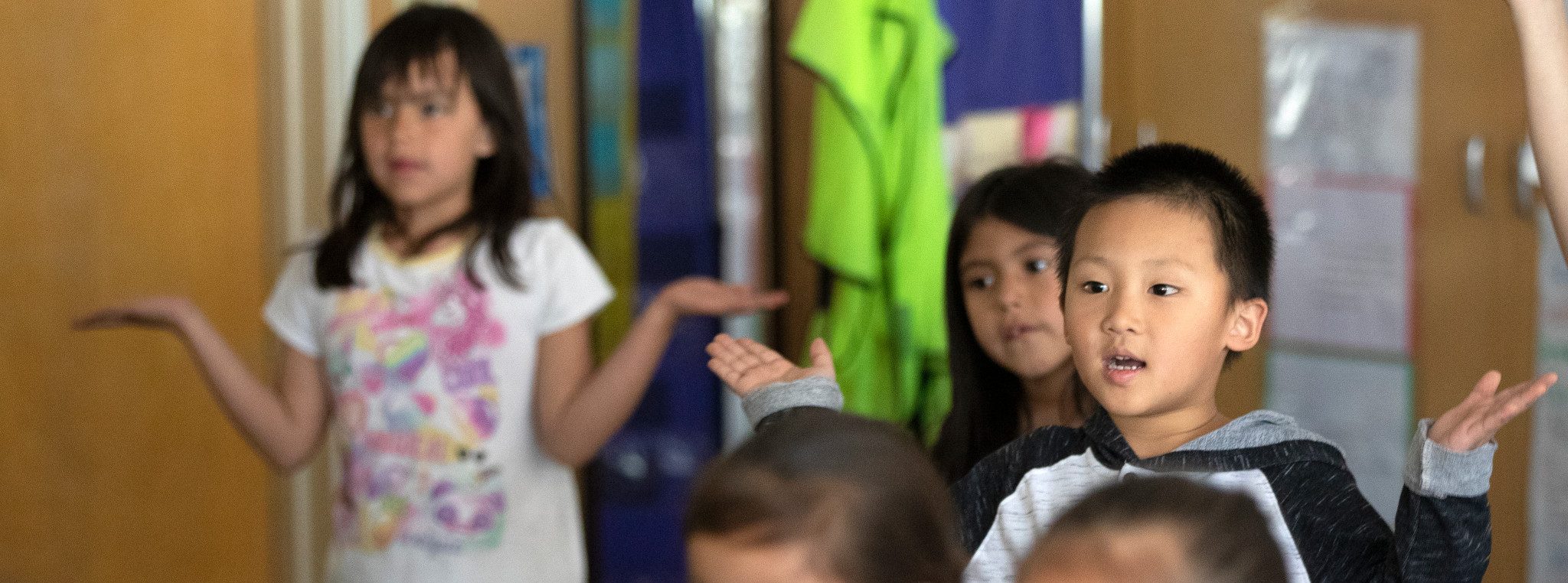 Young students standing in classroom.