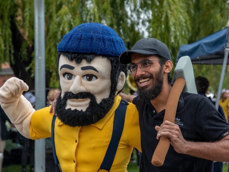 N A U Lumberjack posing for photo with student.