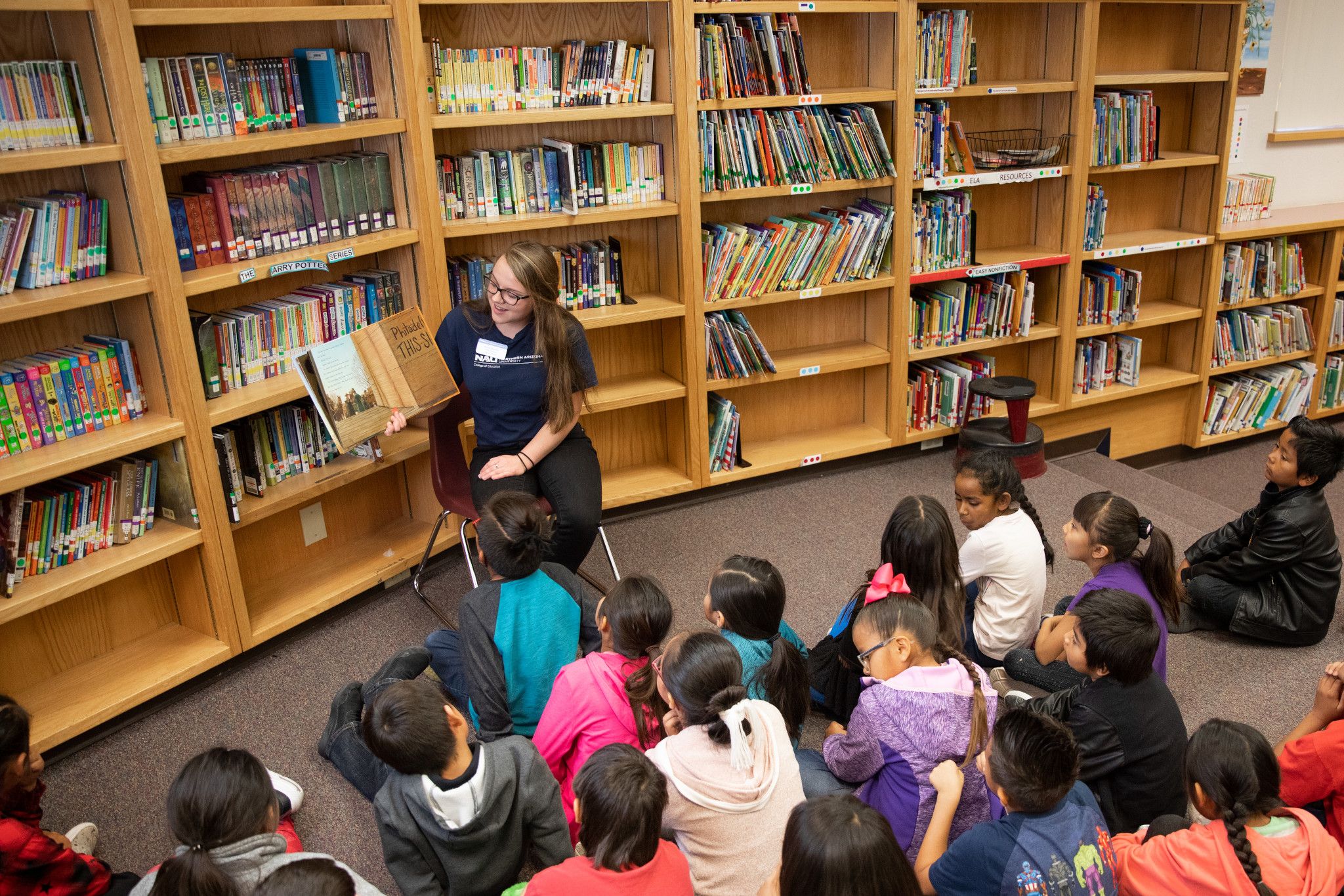 N A U student reading a book to a class.