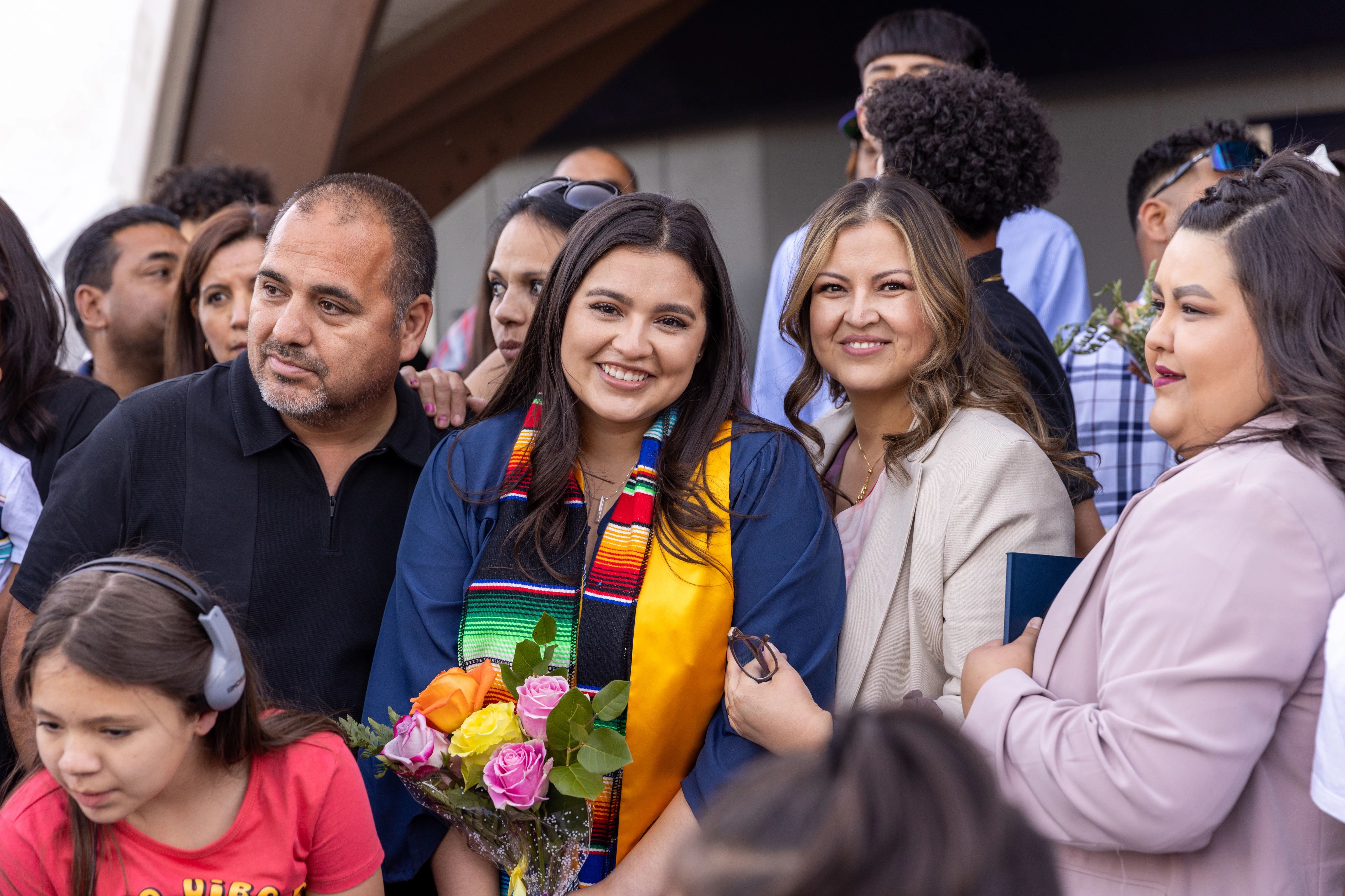 N A U student posing for photo with her friends and family at commencement.