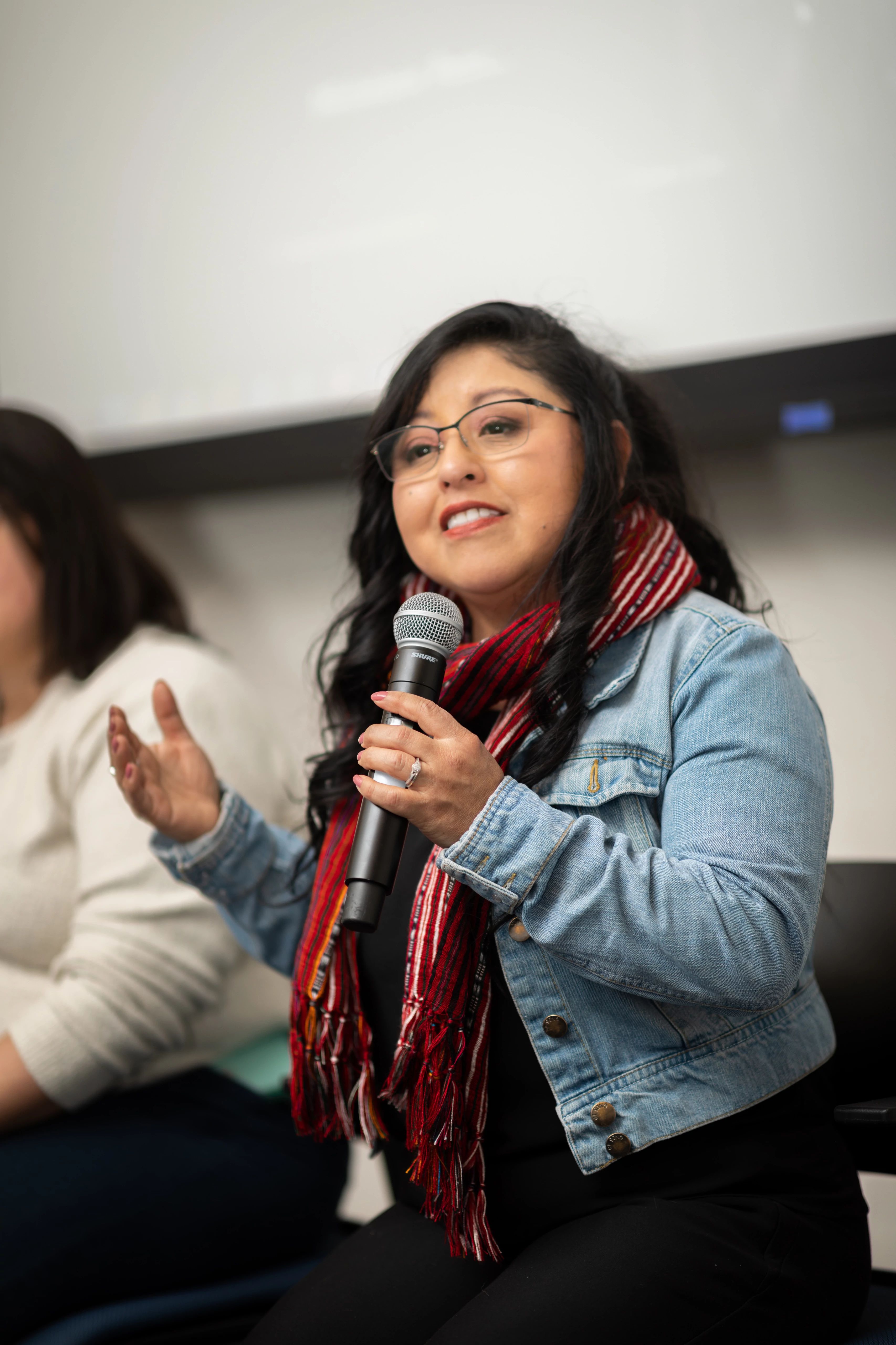 N A U professor using a microphone to talk to a room full of people.