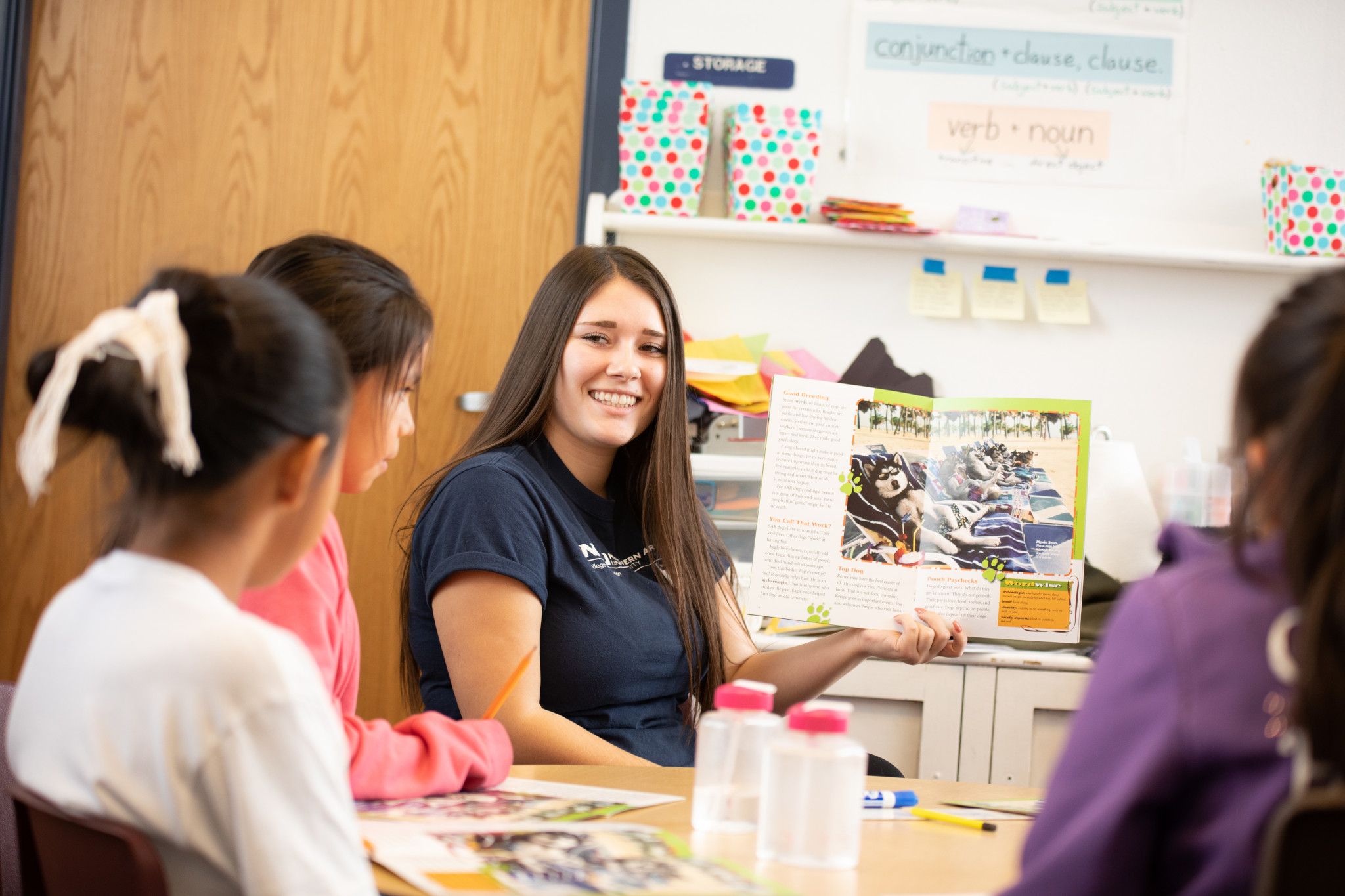 Teacher in the College of Education building, reading a book to kids.