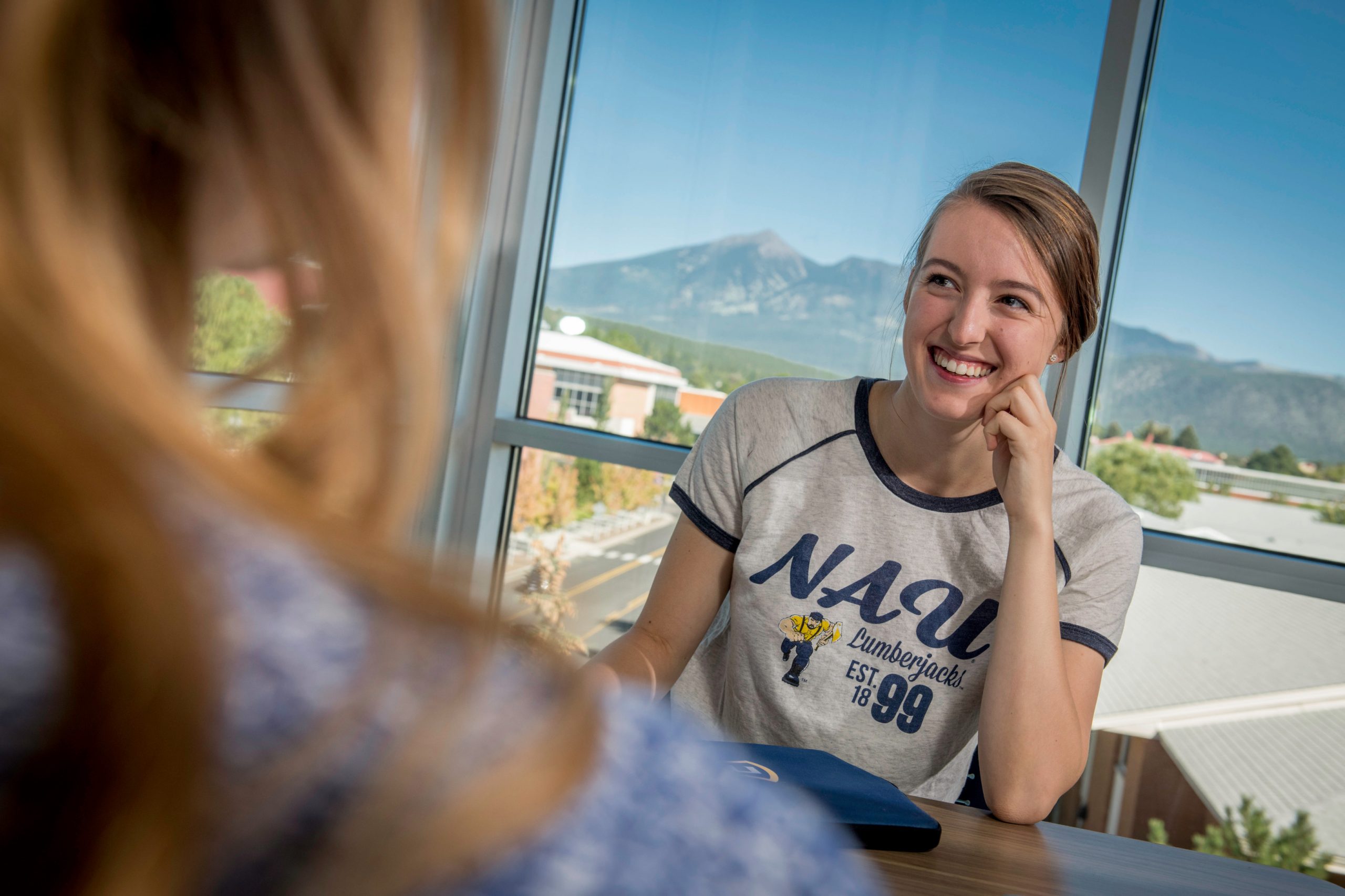 Student smiling while wearing vintage styled N A U shirt.