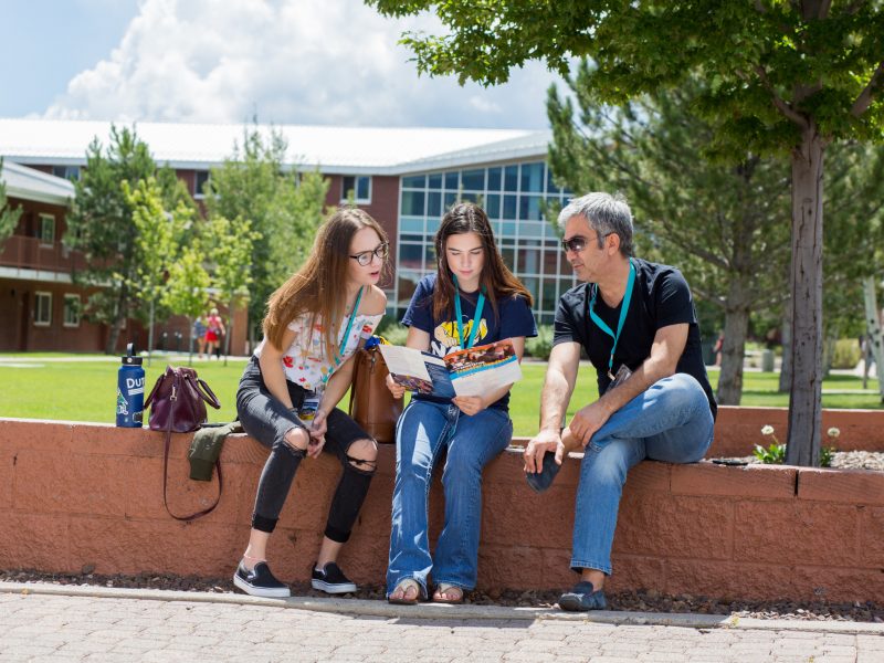 Potential N A U family looking over transfer brochure.
