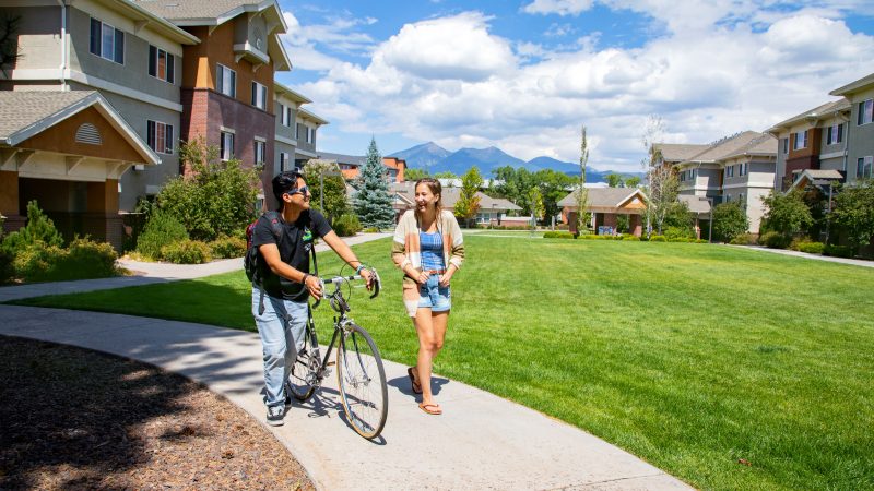 A photo of students walking together near residence hall on Flagstaff mountain campus.
