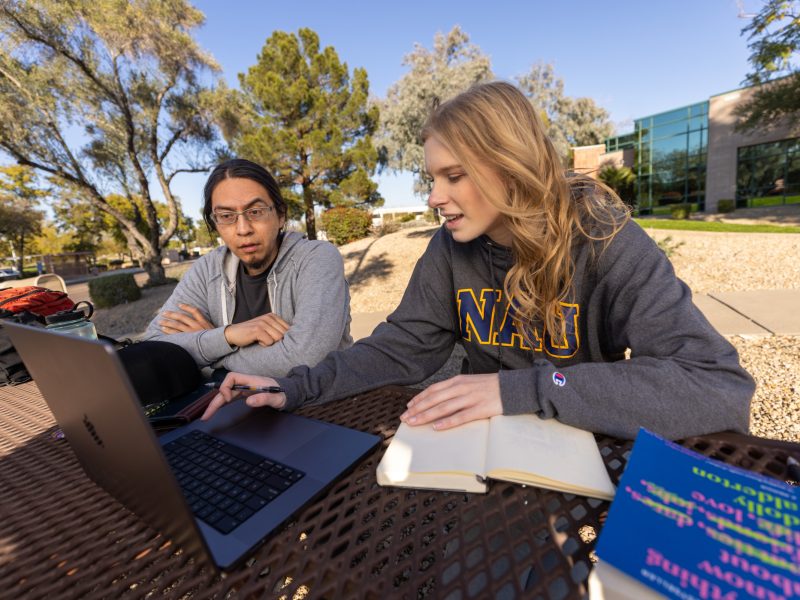 A photo of students looking at a computer.