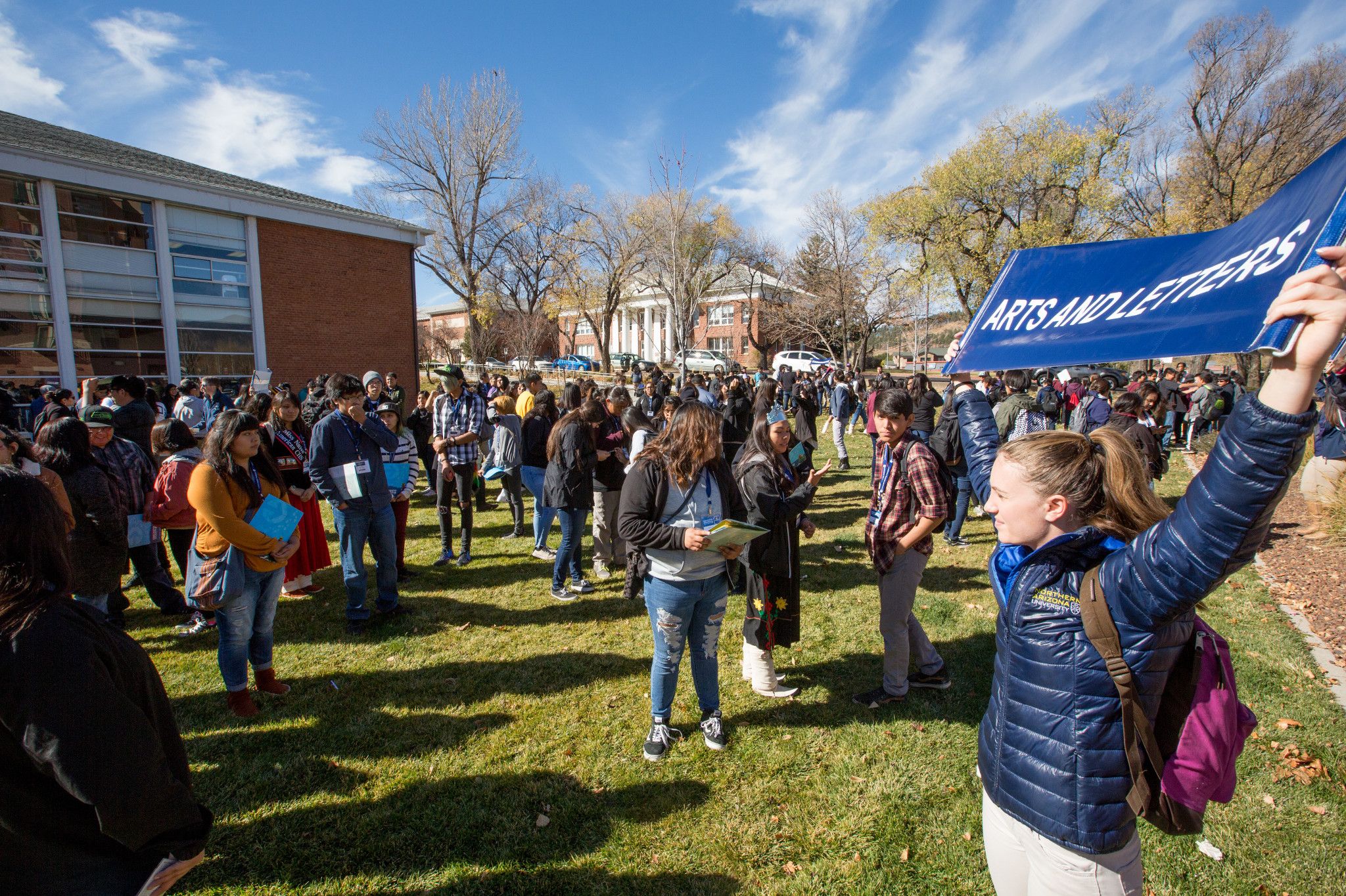 True Blue Ambassador holds sign during campus event.